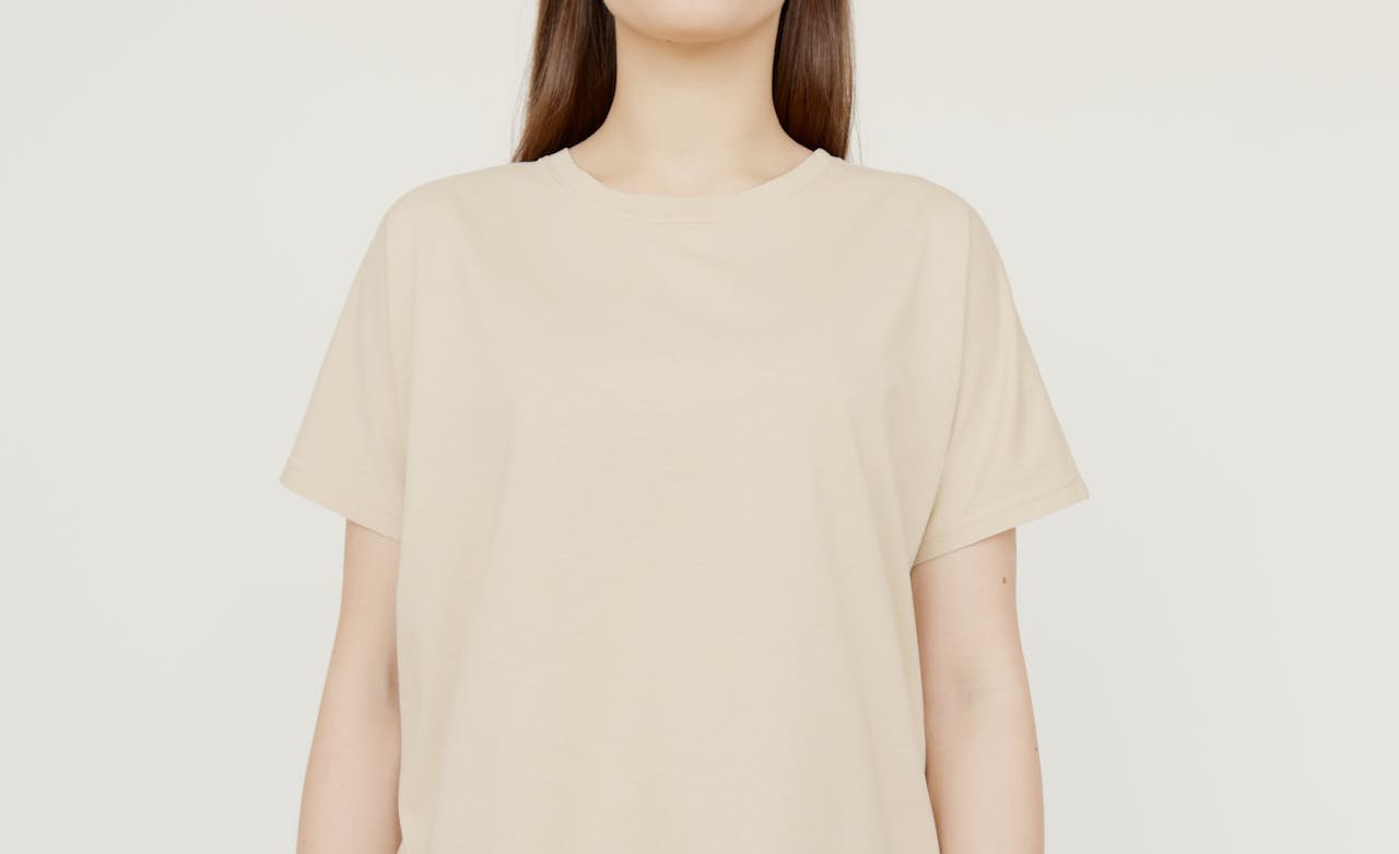 Simple beige shirt mockup in studio setting, ideal for clothing design presentations.