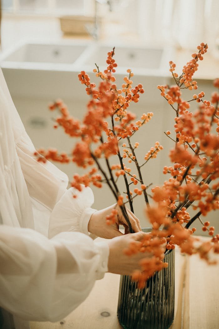 Elegant autumn floral arrangement in a modern vase indoors with soft lighting.