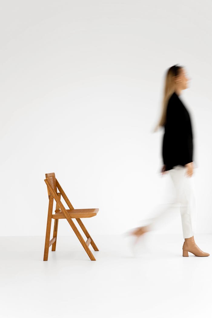 Blurred motion of a woman in black and white against a minimalist background.